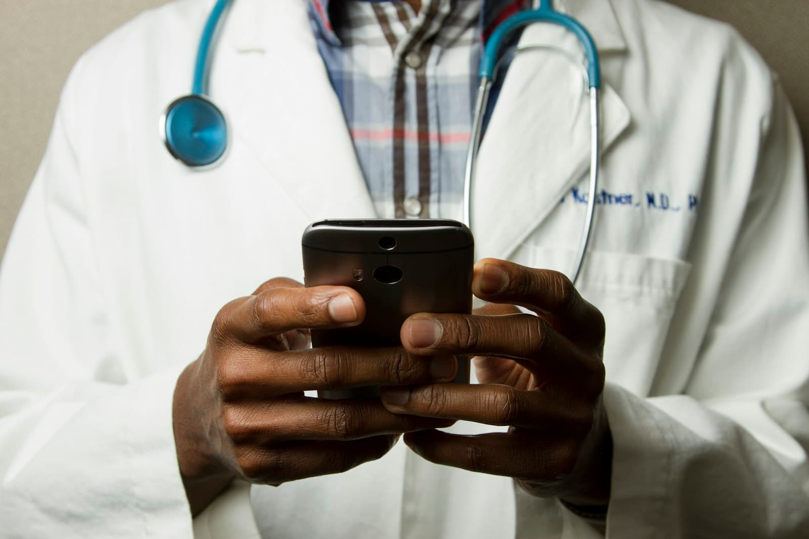 Doctor in a white coat using a phone